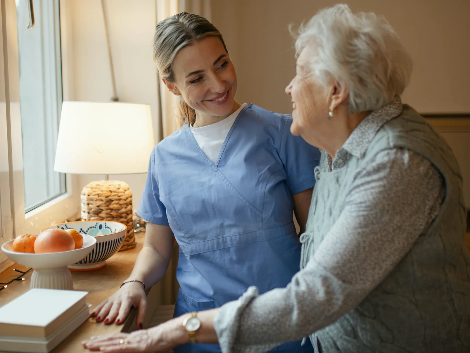 Home health clinician supporting an older adult during a visit
