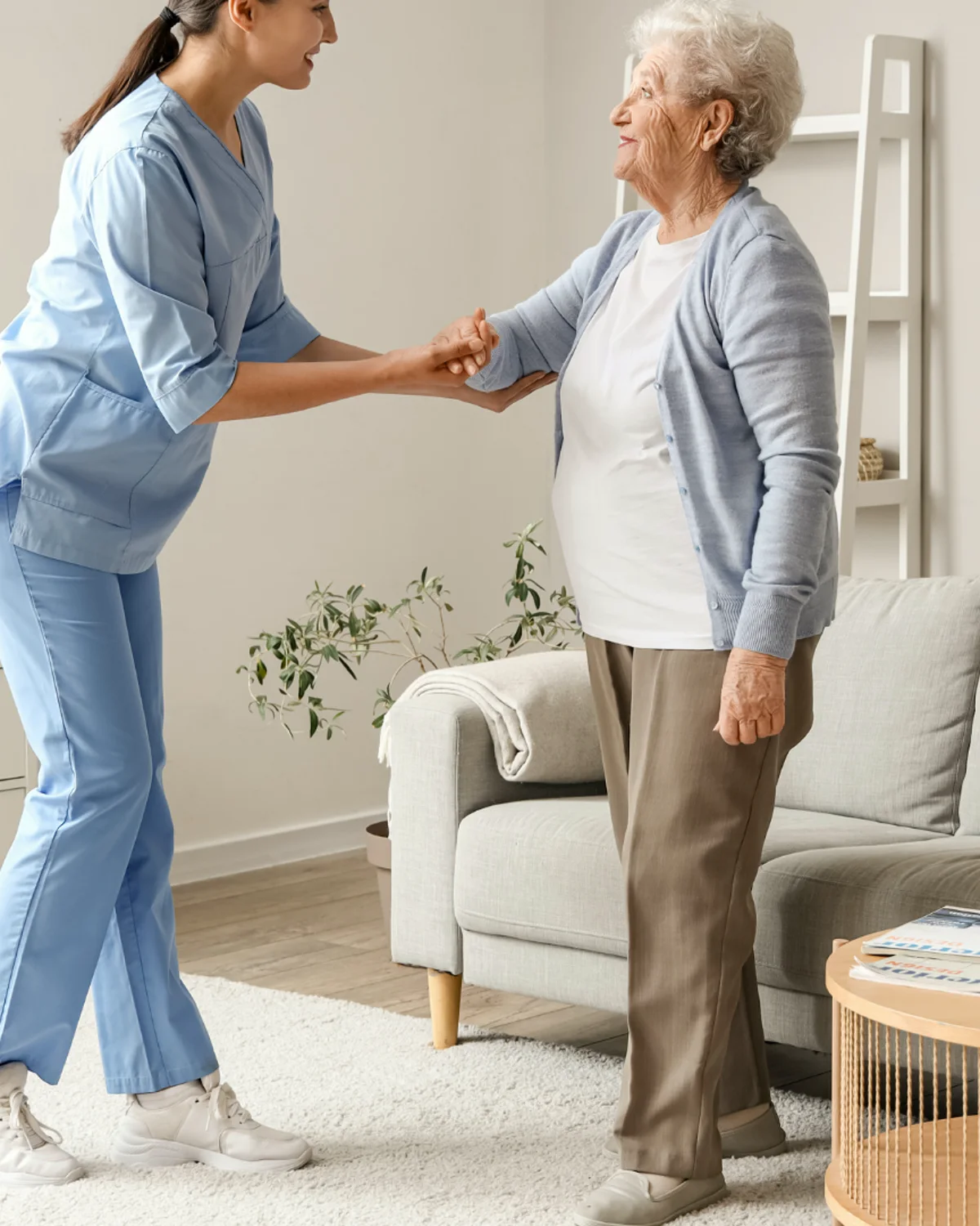A therapist supporting an older adult with standing and mobility goals